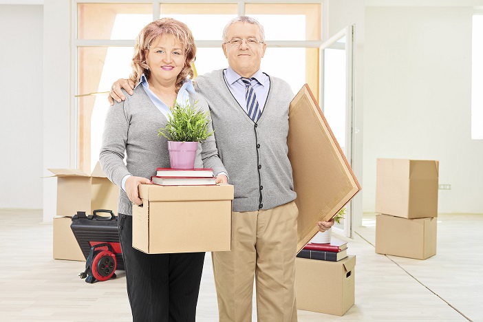 Image of a couple moving, and carrying boxes